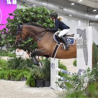 Inez DiNino riding a jumper horse over a fence during training at BluSalt Farm near World Equestrian Center in Ocala Florida